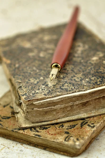 Фонтанная ручка на старых книгах — стоковое фото