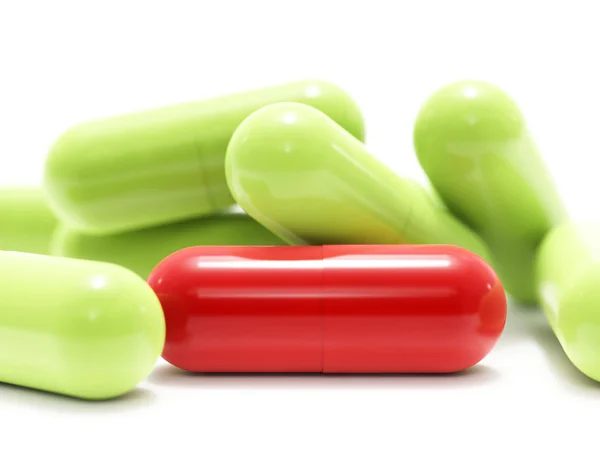 Pílulas vermelhas e verdes em branco — Fotografia de Stock