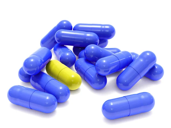 Pílulas azuis e amarelas em branco — Fotografia de Stock