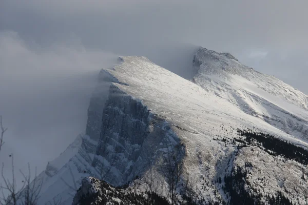 Sneeuw waait van de top van een berg — Stockfoto
