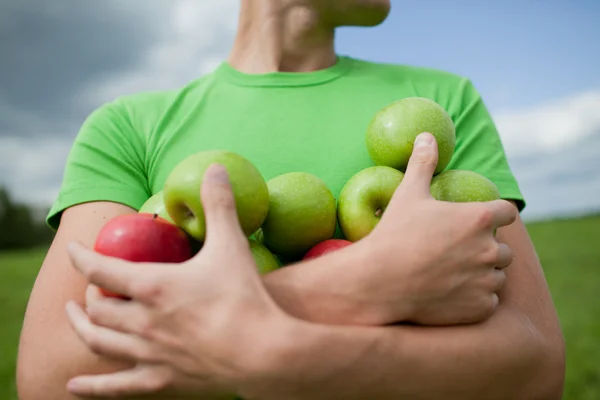 Apples in the hands of a strong guy — Stock Photo, Image
