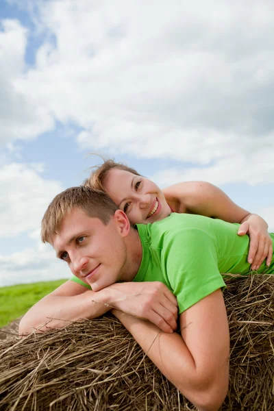 Couple of young lying on the hay — Stock Photo, Image