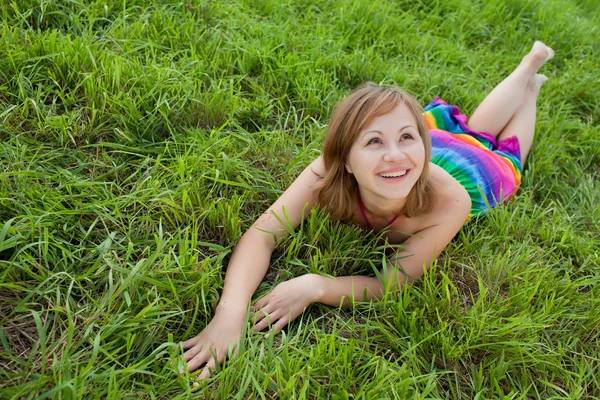 Fröhliches Mädchen auf dem Gras, das nach oben blickt — Stockfoto