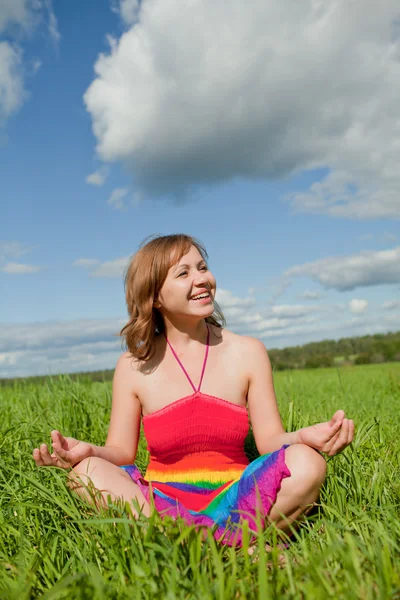 Dívka meditaci na trávě a s úsměvem — Stock fotografie