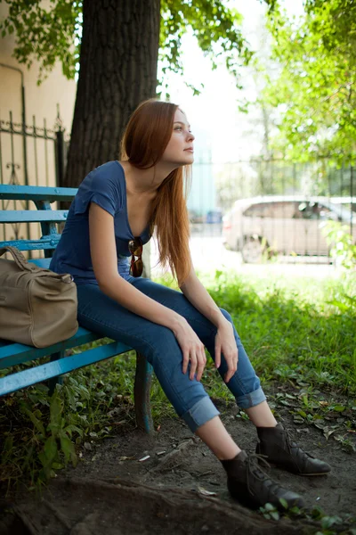 Gadis sedih duduk di bangku taman — Stok Foto