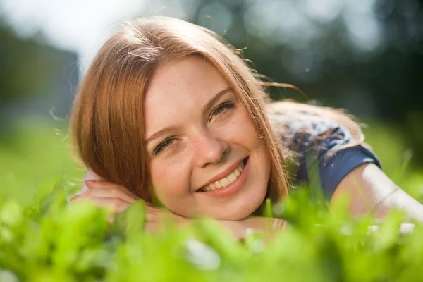 Lány feküdt a fűben, és mosolyogva — Stock Fotó