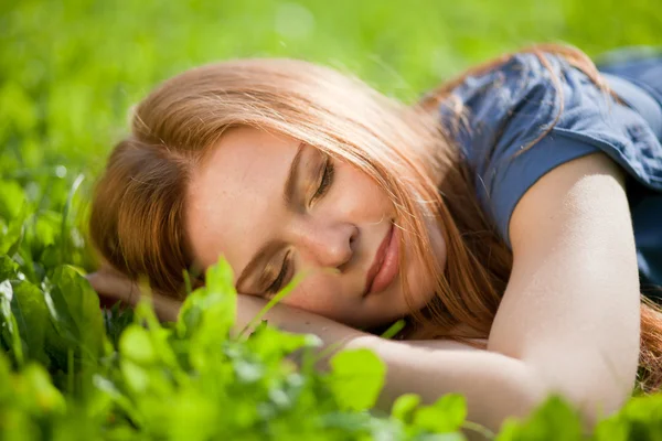 Dívka ležela na trávě a klidně spí — Stock fotografie