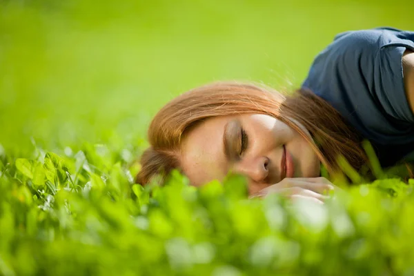 Dívka ležela na trávě a klidně spí — Stock fotografie