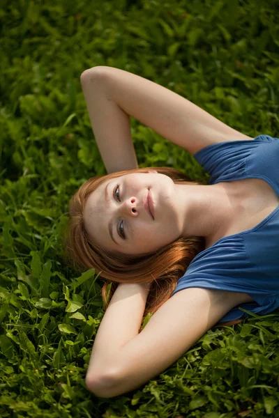 Menina deitada na grama e sorrindo — Fotografia de Stock