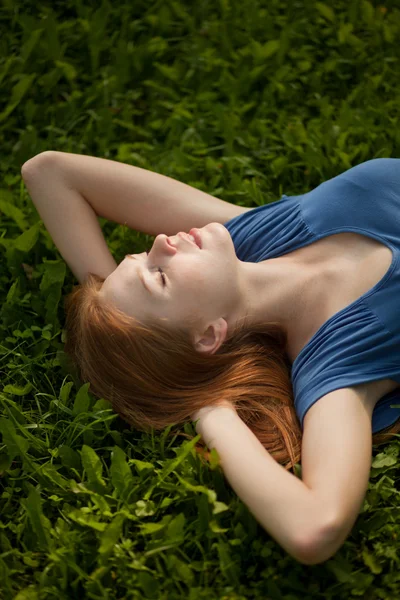 Meisje liggen op het gras en rustig slapen — Stockfoto