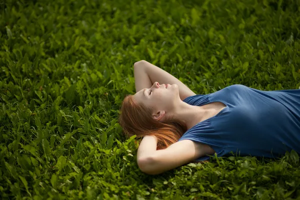 Chica acostada en la hierba y durmiendo tranquilamente — Foto de Stock