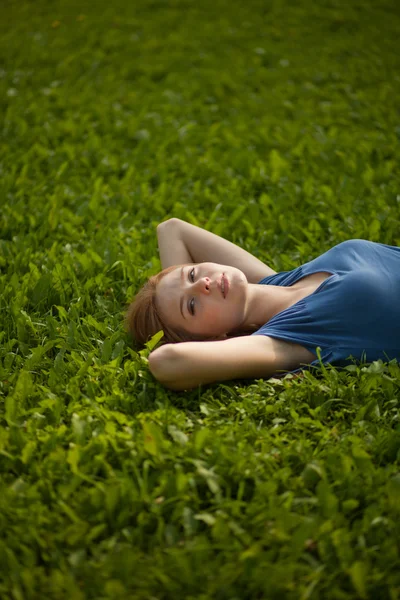 Девушка лежит на траве и улыбается — стоковое фото