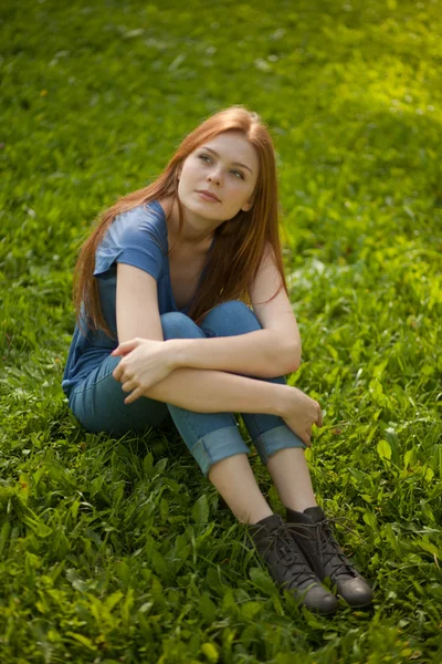 Bella ragazza dai capelli rossi seduta sull'erba — Foto Stock