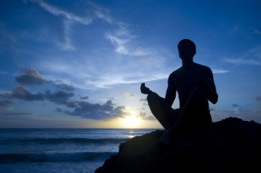 Sun - genç adam Sahilde meditasyon tutulması