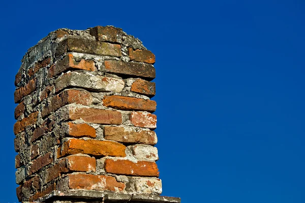 Старый кирпичный дымоход и голубое небо — стоковое фото