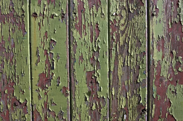 Green paint peeling from a wooden panel door Stock Photo