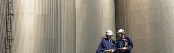 Dělníci a průmyslové palivové nádrže — Stock fotografie