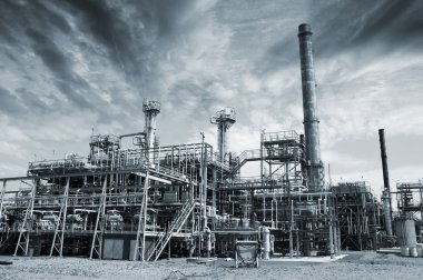 Oil refinery with dark storm clouds clipart