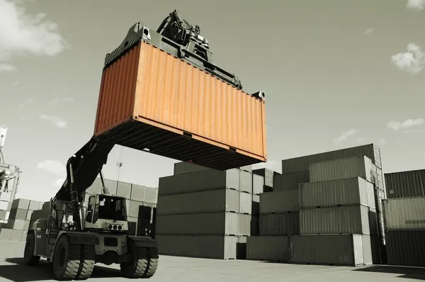 Forklift hoisting cargo container — Stock Photo, Image