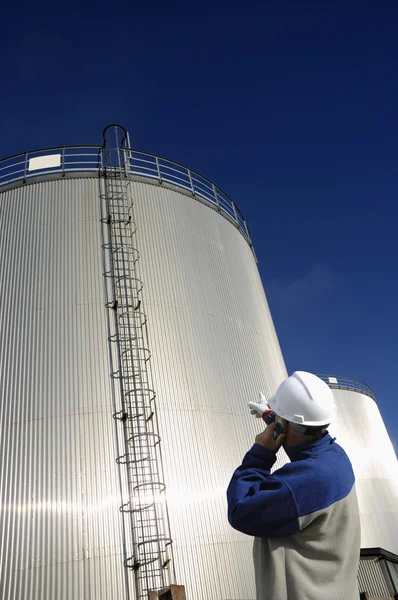 Engineer and fuel storage towers — Stock Photo, Image