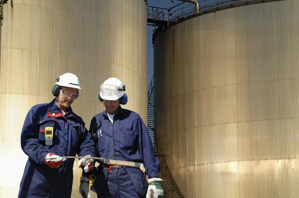 Trabalhadores do petróleo e torres de armazenamento — Fotografia de Stock