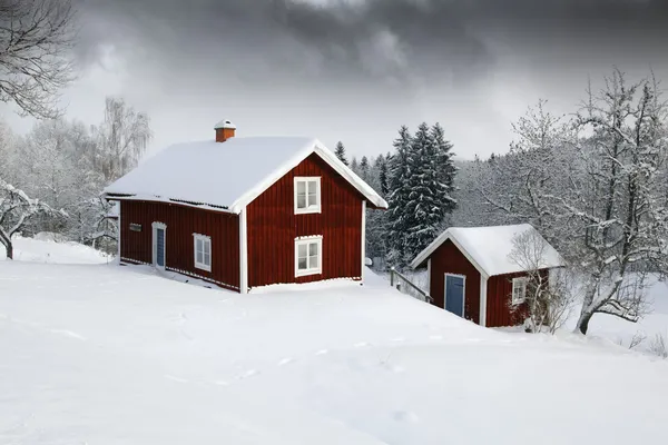 Röd stuga i snöiga landskap — Stockfoto
