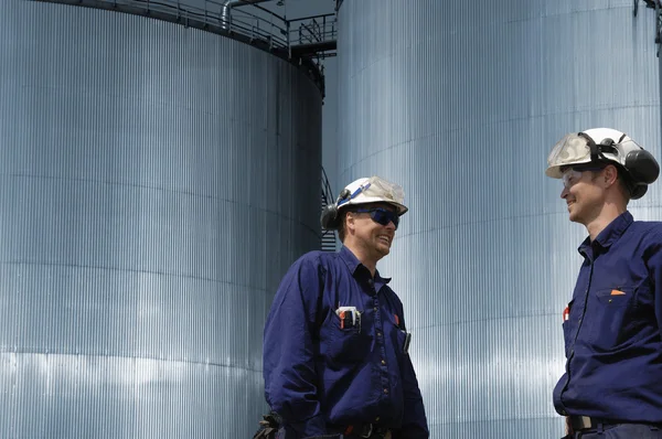 Trabajadores del petróleo y torres de almacenamiento de combustible — Foto de Stock