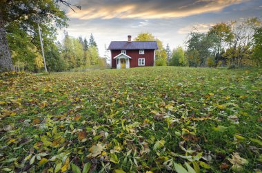 Red cottage and autumn leaves clipart