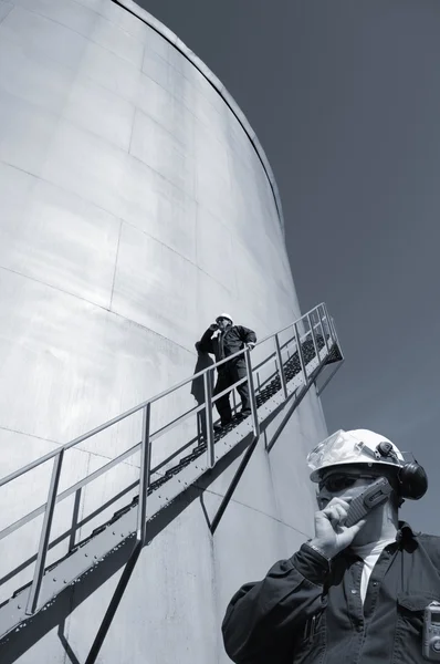 Olaj-munkás és az üzemanyag-tároló tornyok — Stock Fotó