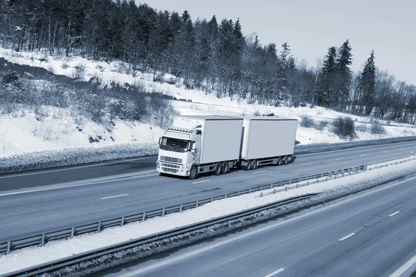 Lastwagen fährt auf schneebedeckter Autobahn — Stockfoto