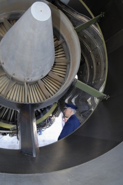 Airline captain inspecting jet-engine clipart