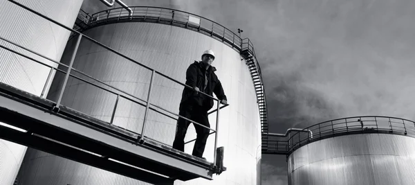 Працівник НПЗ та нафтова вежа — стокове фото