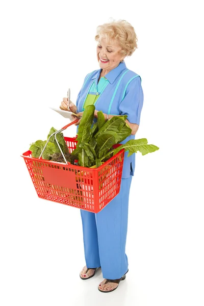 Äldre kvinna kontrollerar inköpslista — Stockfoto