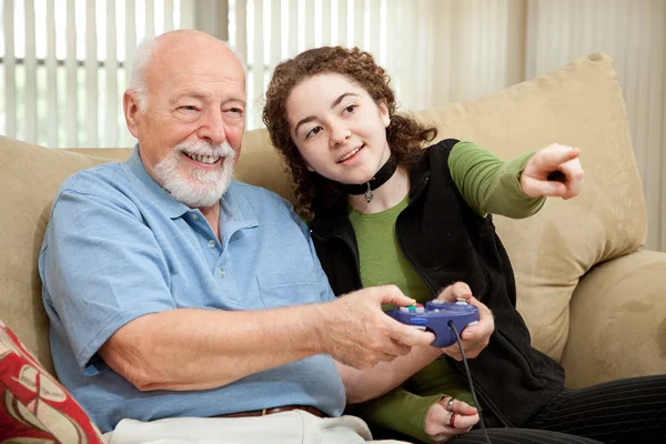 Teenager hilft Opa mit Videospiel — Stockfoto