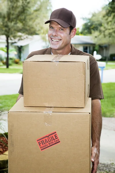 Homem de entrega carrega pacotes — Fotografia de Stock