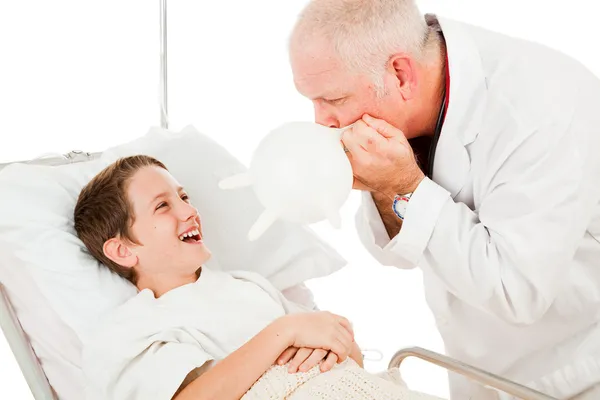 Хлопчик сміється над лікар — стокове фото