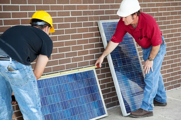 Os eletricistas medem painéis solares — Fotografia de Stock
