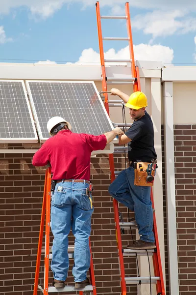 Les travailleurs installent des panneaux solaires — Photo