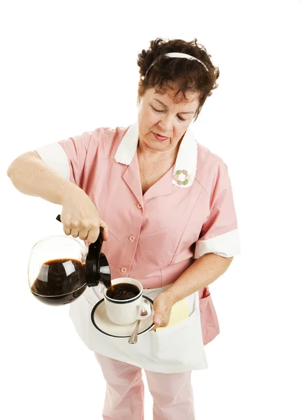 Kellnerin schenkt Kaffee ein - isoliert — Stockfoto