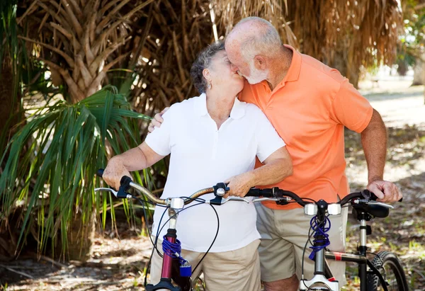 Bicycling Seniors Kiss — Stock Photo, Image