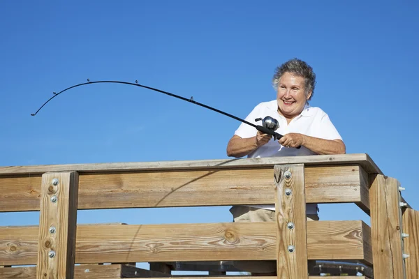Senior Lady carretéis em peixes — Fotografia de Stock