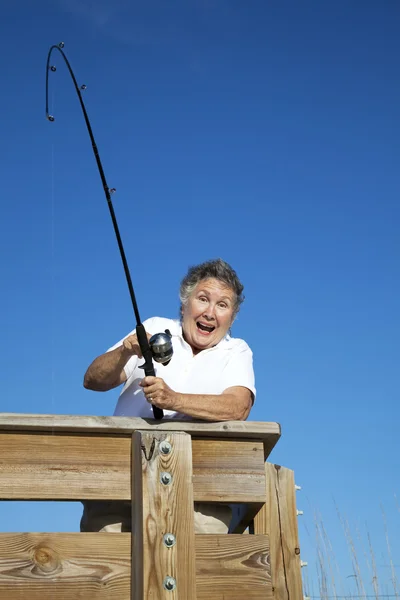 年配の女性が魚をキャッチします。 — ストック写真
