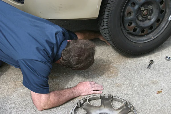 Mechaniker schaut unter Auto — Stockfoto