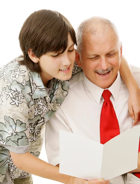 Filho lê cartão de saudação ao pai — Fotografia de Stock