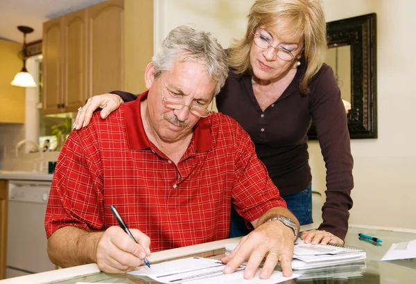 Äldre par - signering pappersarbete — Stockfoto