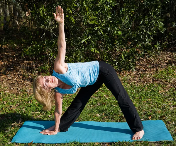 Zralá žena jóga - trojúhelník pozice — Stock fotografie
