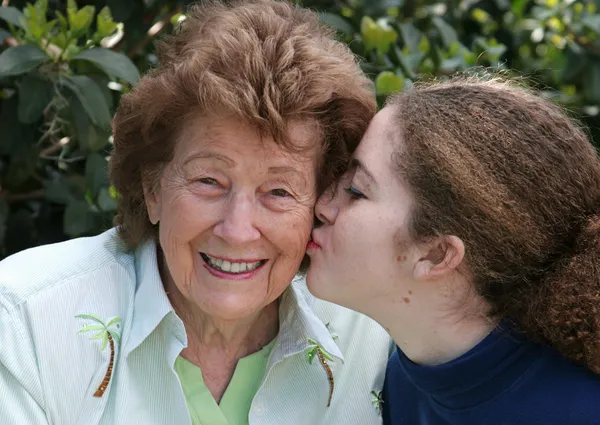 Девочка целует бабушку — стоковое фото