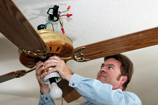 Elektrikçi tavan fanı kaldırır — Stok fotoğraf