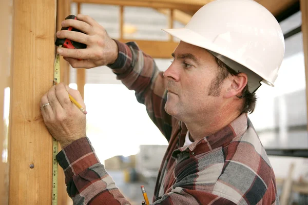 Pracownik budowlany bierze pomiary — Zdjęcie stockowe