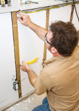 Electrician Installs Wiring in Wall clipart